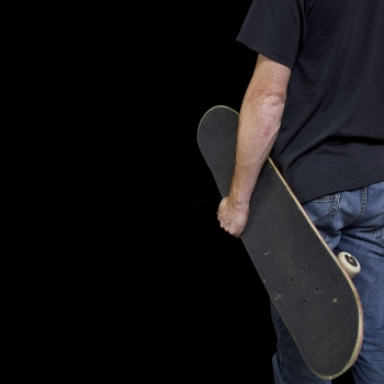Hold the skateboard with grip tape outward